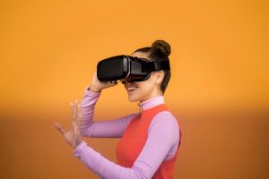 A woman reaches out while wearing VR glasses.