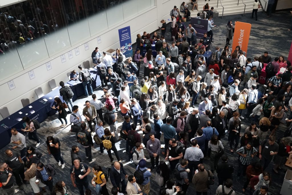 A large crowd meets at a tradeshow.